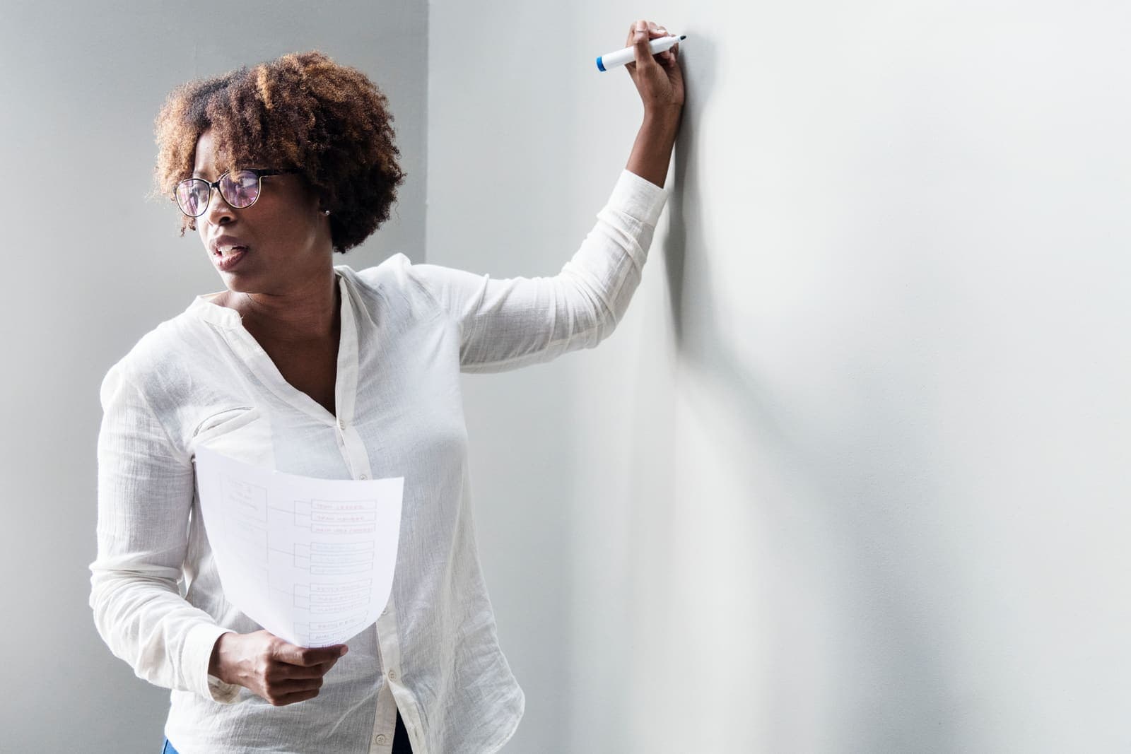 Educator writing at a whiteboard